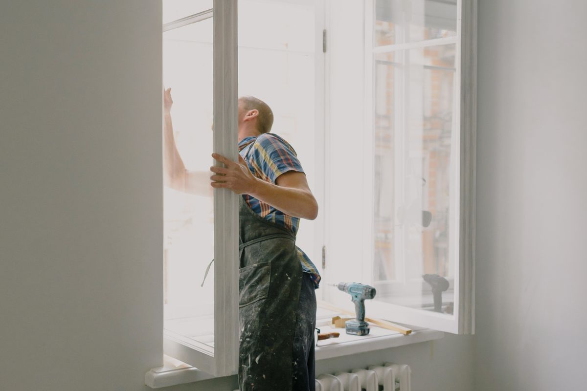 Window installer fitting a new window